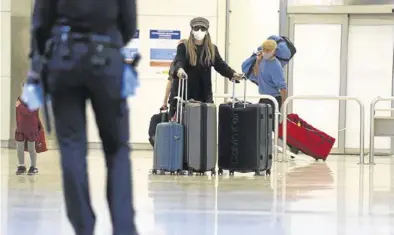  ?? DAVID CASTRO ?? Una pasajera con mascarilla, en el aeropuerto de Barajas, ayer.