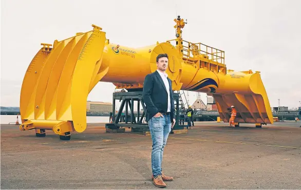  ??  ?? ENERGY RELEASE: Mocean Energy founder Cameron McNatt with his company’s Blue X at Rosyth Docks before its journey north.