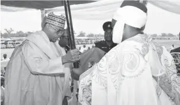  ??  ?? Gov. Ibrahim Gaidam of Yobe State (left) presents the Staff of Office to Emir of Ngelzarma, Alhaji Muhammadu Zanna Mai Yeri Ibn Isa III in a ceremony at Ngelzarma Town in Yobe State yesterday Photo: Yobe Govt. House