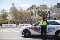  ?? AMANDA ANDRADE-RHOADES / THE WASHINGTON POST ?? Members of the National Guard and police block off Constituti­on Avenue near the U.S. Capitol in Washington, D.C., where two Capitol police officers were struck by a vehicle that rammed into a barricade on Friday.