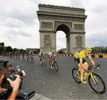  ??  ?? Auf diesen Moment haben die Fotografen gewartet: Chris Froome (rechts) fährt lächelnd über den Champ Elysees, seinem Tour-Sieg entgegen. Foto: David Stockman/dpa