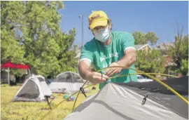  ?? ASHLEE REZIN GARCIA/SUN-TIMES PHOTOS ?? Fran Tobin, 59, of Rogers Park, helps erect a “tent city” on a vacant lot at East 63rd Street and South Blackstone Avenue on Thursday.