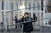  ?? PICTURE: REUTERS ?? An NYPD officer outside the Apple Store in New York yesterday. The FBI wants Apple to help agents hack into Farook’s iPhone by disabling a security feature that destroys data stored on the device.