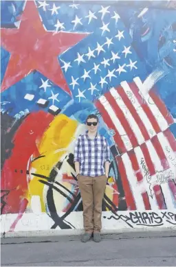  ?? COURTESY PHOTOS ?? Aaron Corbett smiles in front of a mural portraying both the American and German flags. He offers, “The craziest part of my study abroad was… how hard it was to leave a life in Germany.”