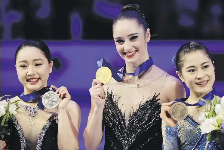  ?? THE ASSOCIATED PRESS ?? Kaetlyn Osmond shows off her gold at the figure skating worlds Friday in Italy with silver winner Wakaba Higuchi, left, and bronze winner Satoko Miyahara, both of Japan.