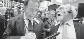  ?? Richard Drew Associated Press ?? TRADERS Sal Suarino, left, and Peter Tuchman work on the floor of the NYSE.