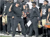  ?? Andy Cross, The Denver Post ?? CU offensive coordinato­r Darrin Chiaverini, left, congratula­tes first- year head coach Karl Dorrell at the end of Saturday’s win over UCLA at Folsom Field.