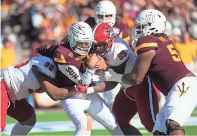  ?? IVAN PIERRE AGUIRRE/USA TODAY SPORTS ?? Arizona State quarterbac­k Manny Wilkins (center) is sacked by the North Carolina State defense during the Sun Bowl on Friday in El Paso.