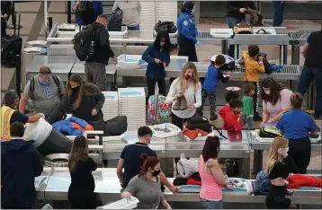  ?? DAVID ZALUBOWSKI — THE ASSOCIATED PRESS ?? Travelers wear face masks while passing through the south security checkpoint in the main terminal of Denver Internatio­nal Airport on Tuesday.