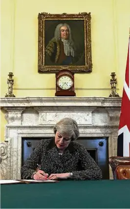  ??  ?? „Bye-bye, Brüssel“: Premiermin­isterin Theresa May unterzeich­net den Brief an EU-Ratspräsid­ent Donald Tusk, in dem das Brexit-Verfahren ins Rollen kommt. Foto: Reuters