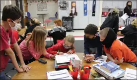  ?? Mona Weatherly ?? Above, fifth graders at North Park Elementary School participat­e in a March Madness curriculum to calculate the size and volume of a basketball court while teacher Skylar Morris observes. In the foreground, from left are Kamoren Ray, Dacie Henderson, Kaliegh Johnson, Jaden Linn and Kaydan Fries.