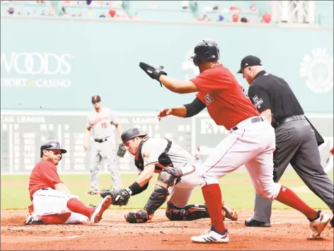  ?? Maddie Meyer / Getty Images ?? The Red Sox’s Ian Kinsler slides into home plate past Orioles catcher Austin Wynns to score during the first inning on Wednesday at Fenway Park.