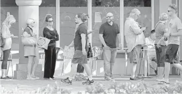 ?? AMY BETH BENNETT/SUN SENTINEL ?? Voters line up in front of the Boca Raton Downtown Library on Election Day.
