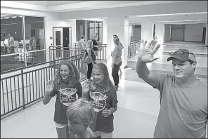  ?? Arkansas Democrat-Gazette/BENJAMIN KRAIN ?? Lillie Tretter (left) and Rachel Maack, seventh-graders this year at Pinnacle View Middle School, wave to friends while touring the new facility Saturday with Rachel’s brother Andrew (foreground) and her dad, BJ Maack.