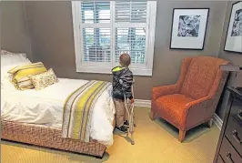  ??  ?? Connor McDonald looks out a window Thursday at Fisher House. Connor and his older brother, Hayden, donated $2,000 they helped raise for the house.