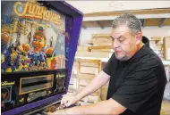  ?? EDWARD KOMENDA/ LAS VEGAS REVIEW-JOURNAL ?? Craig Snelling, 42, tinkers with the insides of a Funhouse Pinball machine at his Las Vegas hobby shop, Billiards ’N More.