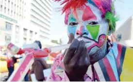  ??  ?? Knowledge Mdluli, a clown blows pipe balloons which he sells to children at a mock mall at the intersecti­on of Jason Moyo Street and 8th Avenue, Bulawayo yesterday