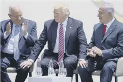  ??  ?? Donald Trump flanked by his Israeli counterpar­t Reuven Rivlin. left, and Israeli prime minister Benjamin Netanyahu in Tel Aviv