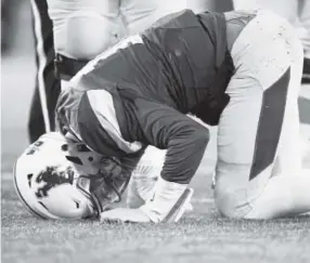  ??  ?? Wyoming quarterbac­k Josh Allen kneels in pain after being hit by the San Diego State defense in the Mountain West championsh­ip game. AAron Ontiveroz, The Denver Post