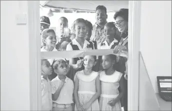  ?? (DPI photo) ?? Minister of Public Telecommun­ications, Catherine Hughes (right) smiles as a pupil of Cumberland Primary cuts the ribbon.