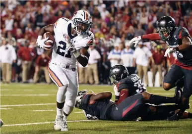  ?? Associated Press ?? Auburn running back Kerryon Johnson, left, runs around the Arkansas defense to score a touchdown in the first half of an NCAA college football game Saturday in Fayettevil­le, Ark.