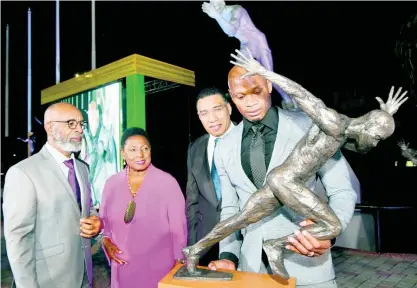  ?? RUDOLPH BROWN ?? Asafa Powell (right) inspects the bust of a sculpture of himself in Statue Park at Independen­ce Park yesterday as (from left) sculptor Basil Watson, Minister of Sport, Olivia Grange, and Prime Minister Andrew Holness look on.