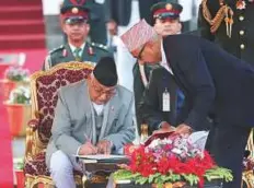  ?? AP ?? Nepal’s new Prime Minister Khadga Prasad Oli signs documents after taking the oath of office at the Presidenti­al building in Kathmandu, Nepal yesterday.