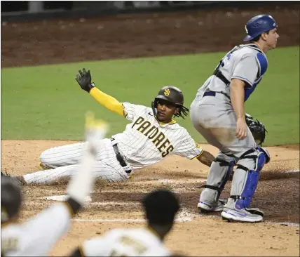  ?? DENIS POROY – GETTY IMAGES ?? DODGERS
The Padres’ C.J. Abrams slides home safely, scoring the winning run on Austin Nola’s sacrifice fly in the 10th inning to defeat the Dodgers.