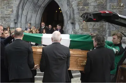  ?? DON MacMONAGLE ?? Farewell to Weeshie: Kerry footballer James O’Donoghue places The Legion flag on GAA broadcaste­r Weeshie Fogarty’s coffin at his funeral in St. Mary’s Cathedral, Killarney yesterday.