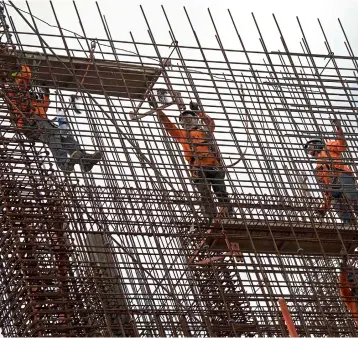  ??  ?? Constructi­on workers are seen on a building site in San Jose, Costa Rica. — AFP photo