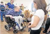  ?? RED HUBER/STAFF PHOTOGRAPH­ER ?? Kenny, a longtime Russell Home resident, gets in some therapy time with Shelton during Thursday’s visit.