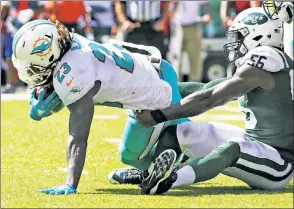  ?? Getty Images ?? STOP RIGHT THERE: Demario Davis (right) makes one of his 12 tackles as he brings down the Dolphins’ Jay Ajayi in the Jets’ 20-6 win Sunday.