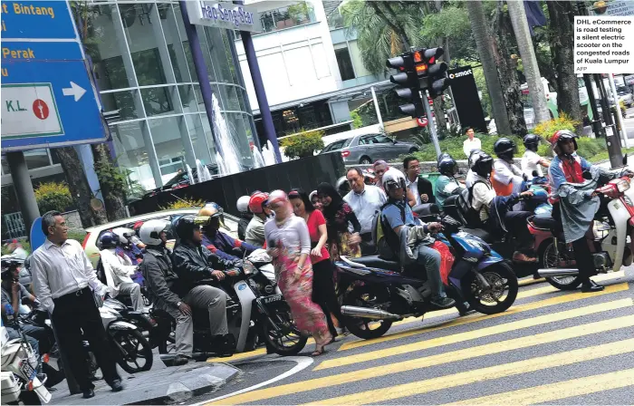  ?? AFP ?? DHL eCommerce is road testing a silent electric scooter on the congested roads of Kuala Lumpur