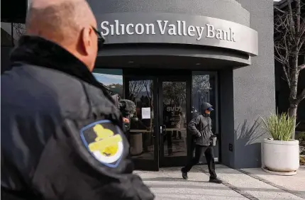  ?? Justin Sullivan/Getty Images ?? A security guard watches a customer leave a Silicon Valley Bank office on Monday in Santa Clara, Calif. Connecticu­t banking experts say it is unlikely the banking crisis will spread to financial institutio­ns in Connecticu­t.