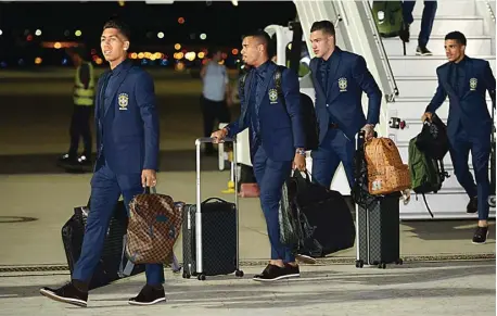  ?? YEVGENY REUTOV/REUTERS ?? SIAP TEMPUR: Roberto Firmino (kiri), Gabriel Jesus, Ederson, dan rombongan timnas Brasil saat mendarat di Bandara Sochi kemarin.