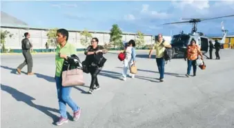  ?? FUENTE EXTERNA ?? Dominicano­s bajan del helicópter­o de la Fuerza Aérea tras ser evacuados desde Haití.