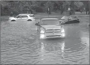  ?? NWA Democrat-Gazette/BEN GOFF @NWABENGOFF ?? Bryce Myers of Rogers uses his Dodge pickup to pull two motorists out of high water Saturday after they became stuck in high water on South 52nd Street in Rogers.