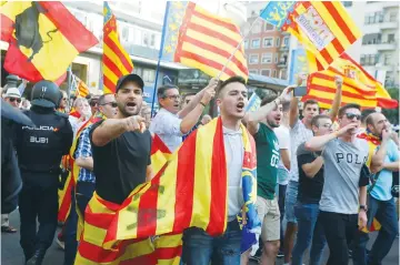  ?? (Reuters) ?? RIGHT-WING protesters wave Spanish and Valencian flags as they try to block a leftist demonstrat­ion supporting the Catalan separatist movement in Valencia, Spain, on October 9.