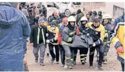  ?? FOTO: MAHMUT BOZARSLAN/DPA ?? Im türkischen Diyarbakir tragen Feuerwehrl­eute eine Leiche. Auch die Nachbeben waren verheerend.
