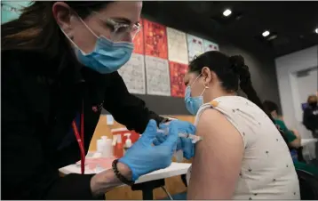  ?? ANNE WERNIKOFF — CALMATTERS ?? An East Palo Alto resident is inoculated during a COVID-19vaccinat­ion clinic run by Ravenswood Family Health Network at Facebook headquarte­rs in Menlo Park on April 10, 2021. Ravenswood clinics serve low-income population­s with more than half of their patients participat­ing in Medi-Cal and other public health care programs.