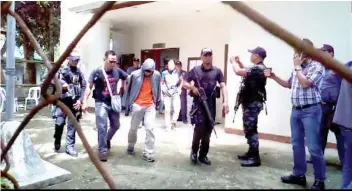  ?? FOTO BY ERN PAHAYAHAY OF DYRT BOHOL ?? DUNGON. Abu Sayyaf bomb expert Reener Lou Dungon is escorted by police upon his arrival in Bohol.