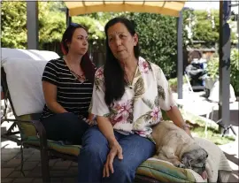  ?? NHAT V. MEYER — STAFF PHOTOGRAPH­ER ?? Nani Lavin, right, wife of Robert Lavin, who was killed by a hit-and-run driver July 5, sits with daughter Kirstan Smith and pug Maggie, 12, in the backyard of their home in San Jose.