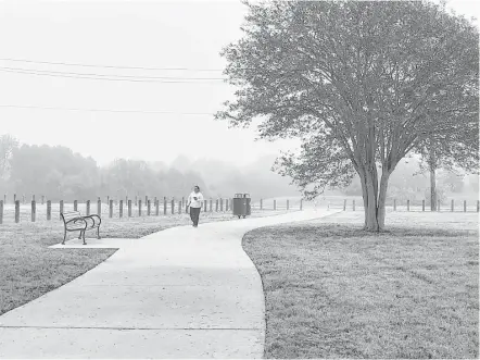  ?? Molly Glentzer / Houston Chronicle ?? Maria Gomez strolls along a path created by the Houston Parks Board across a new green space that was formerly the site of the crime-ridden, abandoned Oakbrook Apartments on De Soto Street in northwest Houston.