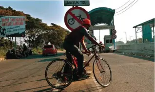  ?? AHMAD KHUSAINI/JAWA POS ?? DIANGGAP BERBAHAYA: Rambu sepeda dilarang melintas dipasang di gerbang pintu masuk Jembatan Suramadu.