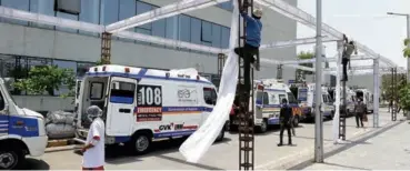  ??  ?? WORKERS building a temporary shade for ambulances transporti­ng COVID-19 patients waiting for admission to the Civil Hospital in Ahmedabad on April 28.