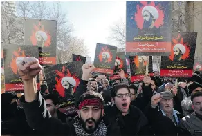  ?? — GETTY IMAGES ?? Iranian men hold portraits of prominent Shiite cleric Nimr al-Nimr during a demonstrat­ion Sunday outside the Saudi Embassy in Tehran over his execution by Saudi authoritie­s.