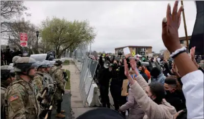  ?? LEAH MILLIS / REUTERS ?? Protesters rally outside the Brooklyn Center Police Department on Monday as it is guarded by members of the police and National Guard, a day after Daunte Wright, 20, was shot and killed by a police officer in Brooklyn Center, Minnesota.