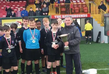  ??  ?? Merville United captain Danny Kilcullen receives the Cup from Terry Hayes after the final. Pic: Merville Utd