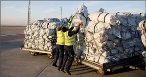  ?? AP/BRAM JANSSEN ?? Workers load pallets with winter supplies, which arrived by air Thursday in Irbil, northern Iraq, from the United Nations refugee agency. The United States delivered 25,000 winterizat­ion kits for displaced people fleeing Islamic State militants.