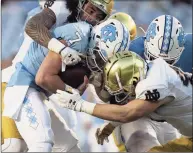  ?? Robert Willett / Associated Press ?? North Carolina QB Sam Howell is sacked by Notre Dame’s Marist Liufau (35) and Drew White (40).